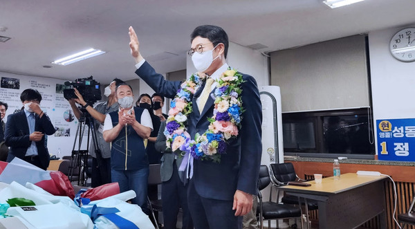 정원오 성동구청장 후보가 당선이 확정되자 목에 꽃다발을 걸고 한 손을 번쩍 들어 선거사무소 관계자들에게 고마움을 전하고 있다. [당선자 제공]