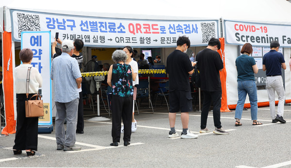 코로나19가 재확산하고 있는 18일 오전 서울 강남구보건소에 설치된 임시선별진료소를 찾은 시민들이 검사 순서를 기다리고 있다. [연합뉴스]