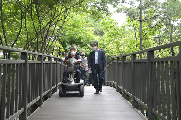 서울 중구 무학봉근린공원에서 지난 22일 김길성 구청장(오른쪽)과 휠체어 이용자 등이 무장애길을 걸어보고 있다.[중구 제공]