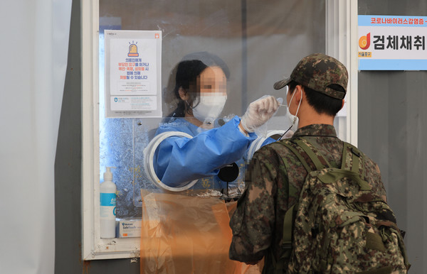 13일 오후 서울역에 마련된 선별진료소에서 시민들이 검사를 받고 있다. [연합뉴스]