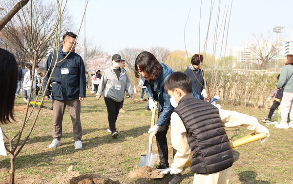 김현주 성동구의장이 한 어린이와 함께 나무를 심고 있다. [성동구의회 제공]