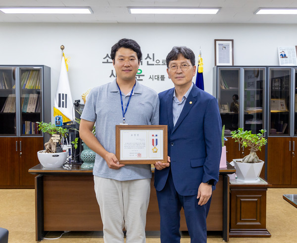 지난달 출근길 한 음식점에서 발생한 화재를 조기 진압한 강북구보건소 정선근 주무관(왼쪽)에게 의장 표창을 수여한 후 최치효 의장이 함께했다.[강북구의회 제공]