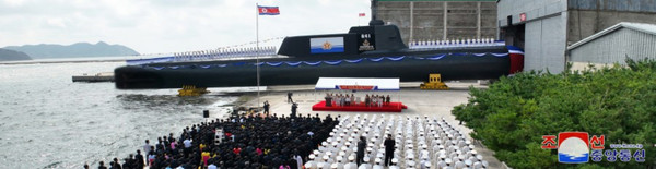 북한이 8일 수중에서 핵 공격이 가능한 전술핵공격잠수함을 건조했다고 밝혔다. 조선중앙통신은 이날 '주체적 해군 무력강화의 새시대, 전환기의 도래를 알리는 일대 사변'이라는 제목의 기사에서 "우리 당의 혁명 위업에 무한히 충직한 영웅적인 군수노동계급과 과학자, 기술자들은 우리 식의 전술핵공격잠수함을 건조해 창건 75돌을 맞는 어머니 조국에 선물로 드렸다"고 보도했다. 지난 6일 열린 진수식에는 김정은 국무위원장과 함께 리병철ㆍ박정천 원수, 김덕훈 내각총리 등 참석했다. [조선중앙통신 홈페이지 캡처]