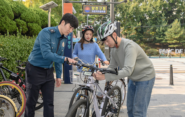 '자전거 지킴이 존'에서 전자칩이 내장된 자전거 번호판을 장착중인 구민의 모습. [양천구 제공]