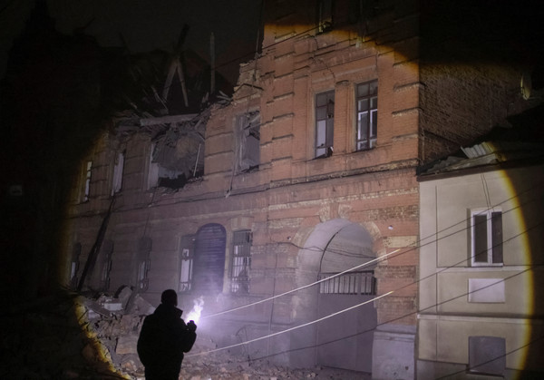 3일(현지시간) 우크라이나 하르키우에서 경찰이 러시아 군의 드론 공격으로 일부 파괴된 건물을 보고 있다. [하르키우 로이터=연합뉴스]