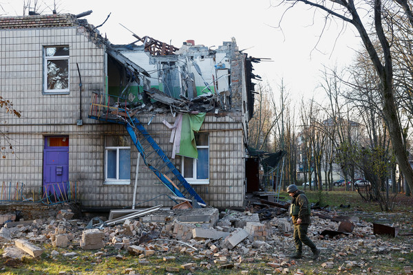 지난 11월 25일(현지시간) 우크라이나 수도 키이우에서 경찰관들이 러시아의 공격으로 파손된 유치원 경내를 살피고 있다. [키이우 로이터=연합뉴스]