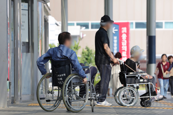 서울대학교병원이 '무기한 휴진'에 돌입한 지 사흘째인 19일 오후 서울 종로구 서울대병원에서 환자가 이동하고 있다. [연합뉴스]