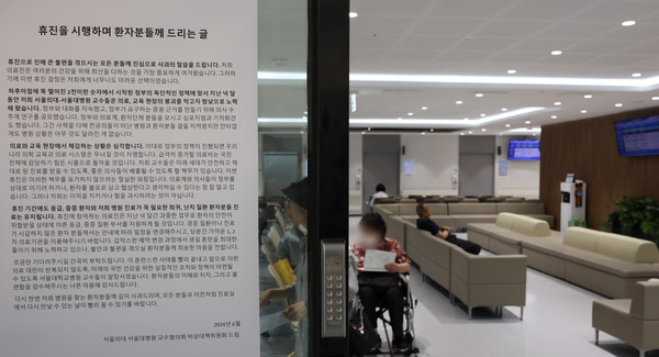 서울대학교병원이 '무기한 휴진'에 돌입한 지 사흘째인 19일 오후 서울 종로구 서울대병원에 서울의대·서울대병원 교수협의회 비상대책위원회가 쓴 '휴진을 시행하며 환자분들께 드리는 글'이 붙어 있다. [연합뉴스]