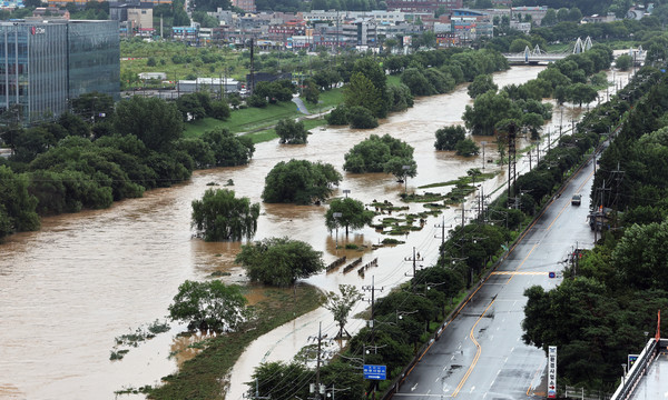 많은 비가 내린 18일 오후 홍수경보가 발령 중인 경기도 오산시 오산천 산책로가 불어난 물에 잠겨 있다. [연합뉴스]