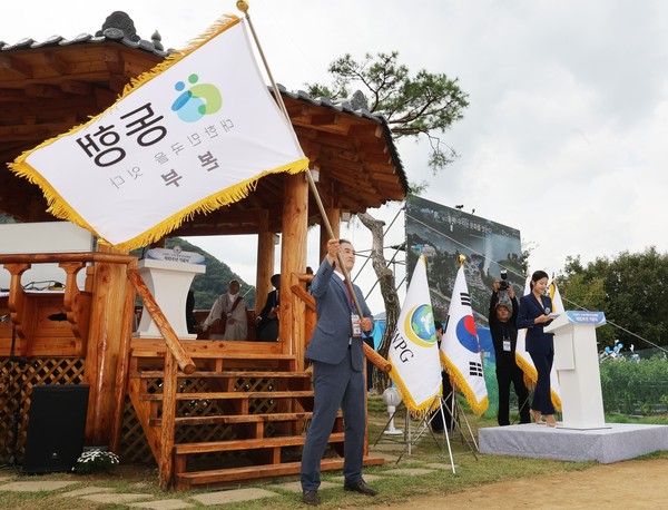 18일 HWPL 평화연수원에서 열린 HWPL 9.18 평화 만국회의 10주년 기념식을 겸해 발족한 동행 캠페인 김동희 추진본부장이 깃발을 흔들고 있는 모습. [HWPL 제공]